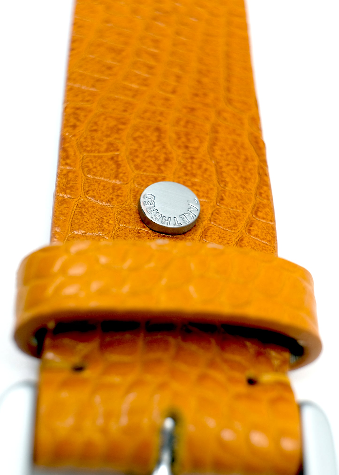 Close-up of the yellow Mississippi Belt showing alligator-embossed leather, a silver buckle, and a silver rivet.