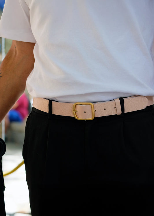 Lifestyle shot of the Nude Pink Grunge Belt worn with black pleated trousers and a white t-shirt.