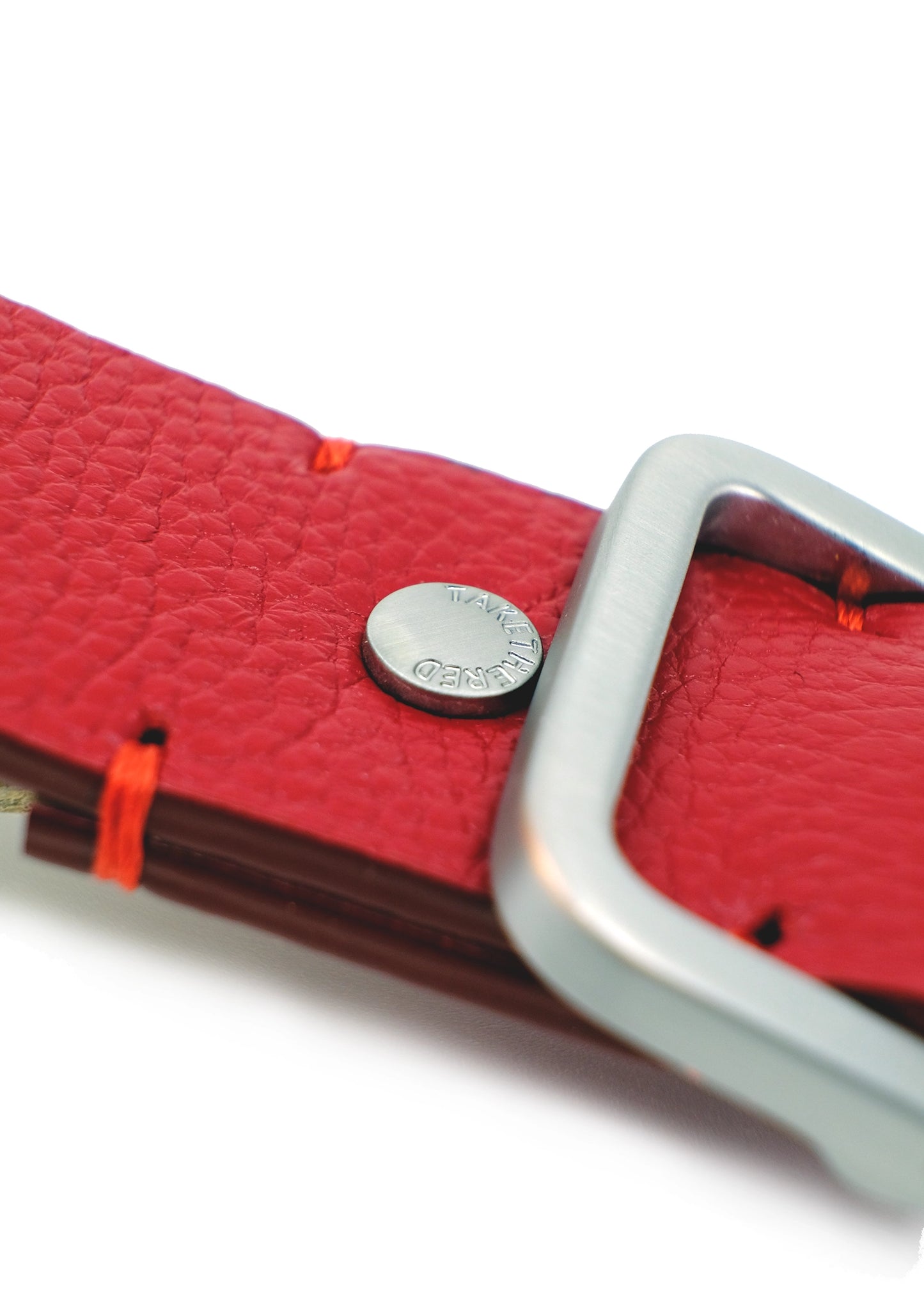 Close-up of Blood Simple Grunge Belt showing red reinforcement stitches and a silver rivet engraved with "BIRD & ASH."