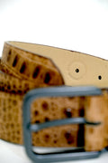 Close-up of desert sand belt interior with "PROUDLY MADE IN PORTUGAL - A DEMOCRACY" embossed stamp.