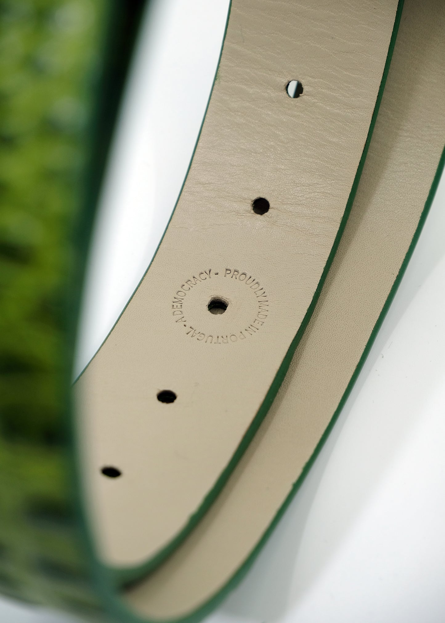 Interior close-up view of the Atomic Green belt showing the cream interior and a "PROUDLY MADE IN PORTUGAL" stamp.