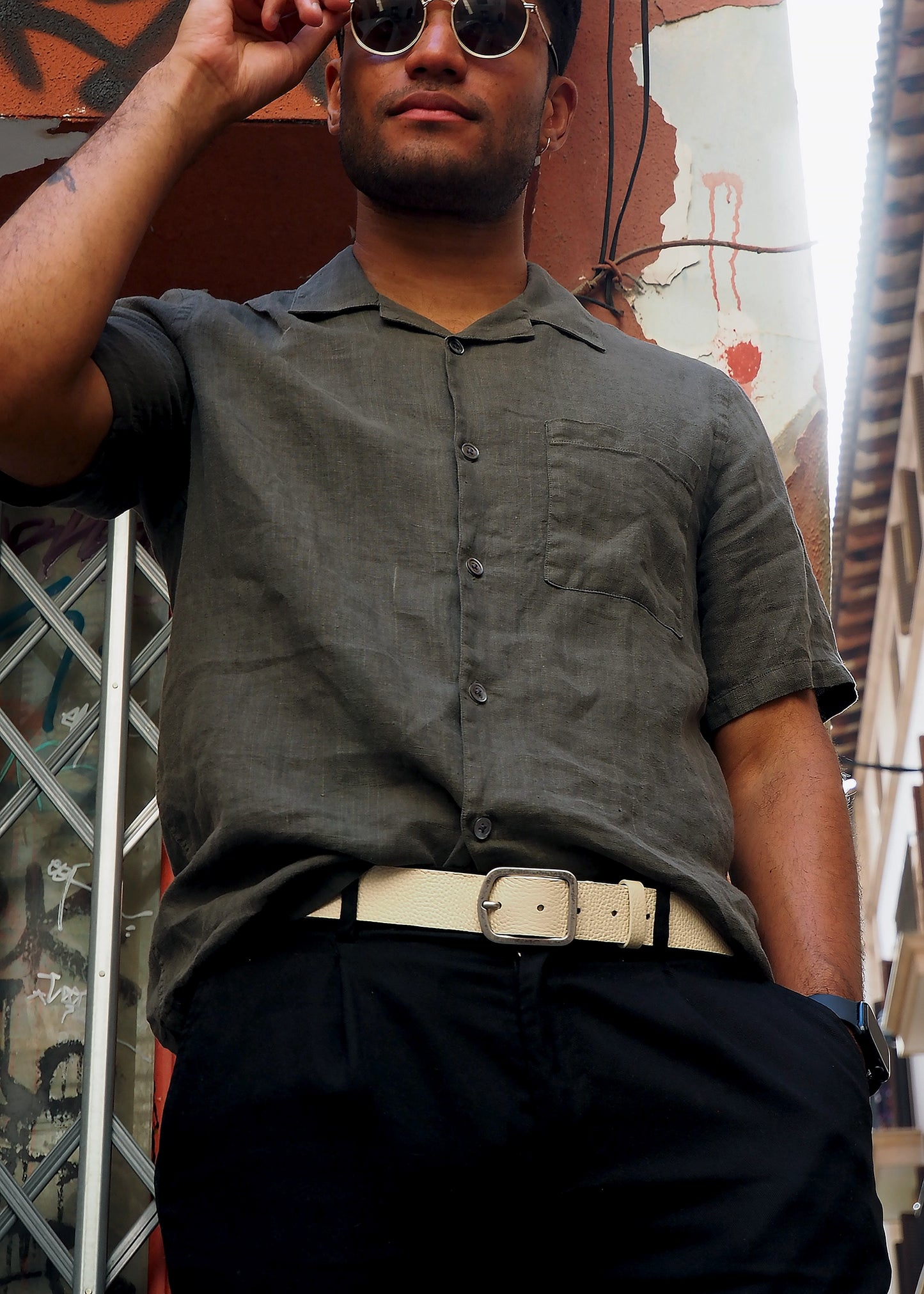 Lifestyle shot of the cream Dusty Spring Grunge Belt worn with black trousers and a grey button-up shirt.