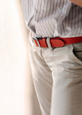 Lifestyle shot of the orange Tatooine Sunset Grunge Belt worn with beige trousers and a striped shirt.