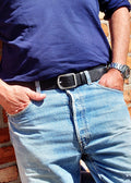 Lifestyle shot of the Pitch Black Grunge Belt in pebble-grain leather worn with light blue jeans and a navy shirt.
