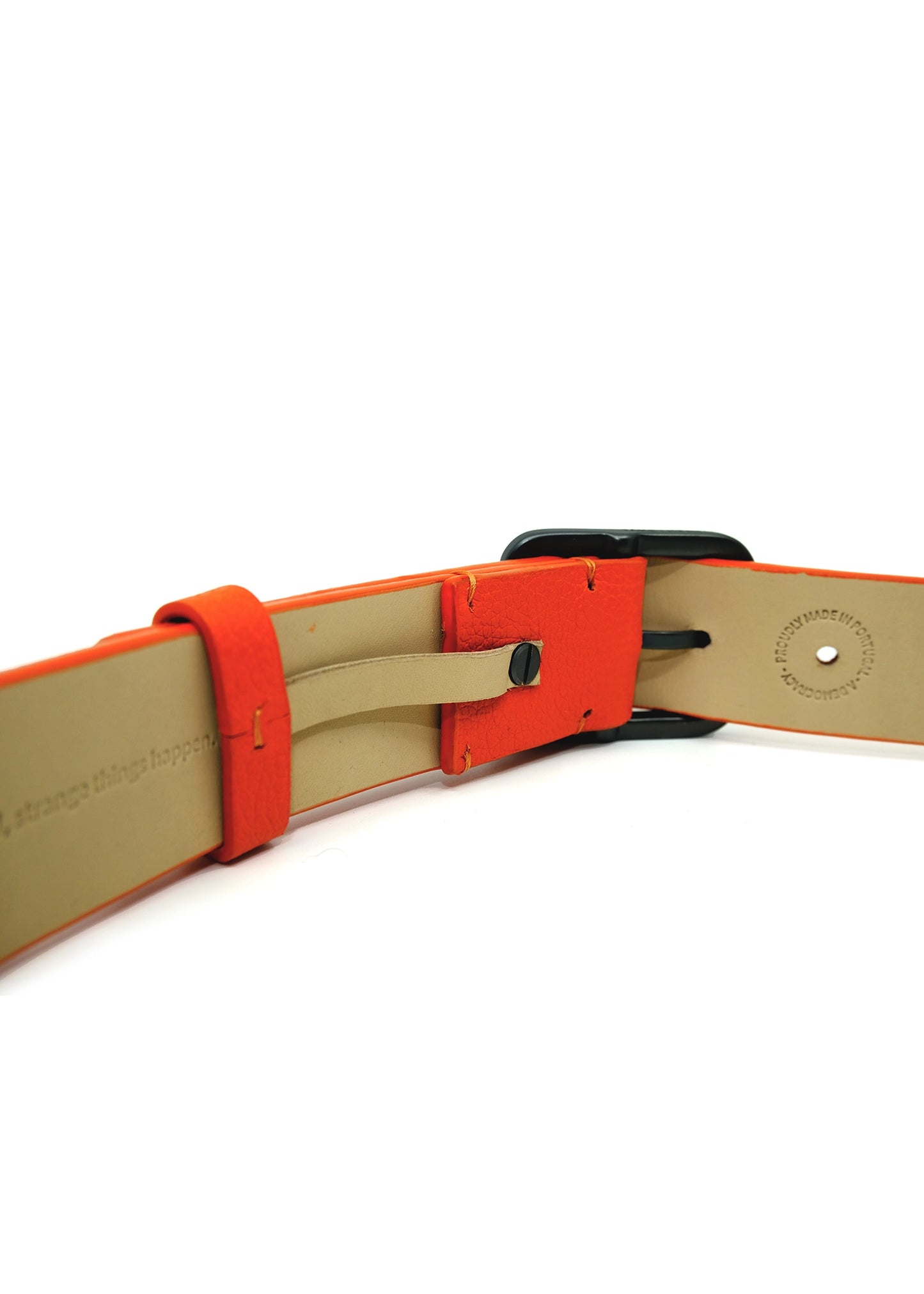 Interior view of an orange belt showing the "MADE IN PORTUGAL" stamp and hidden embossed text on a tan lining.