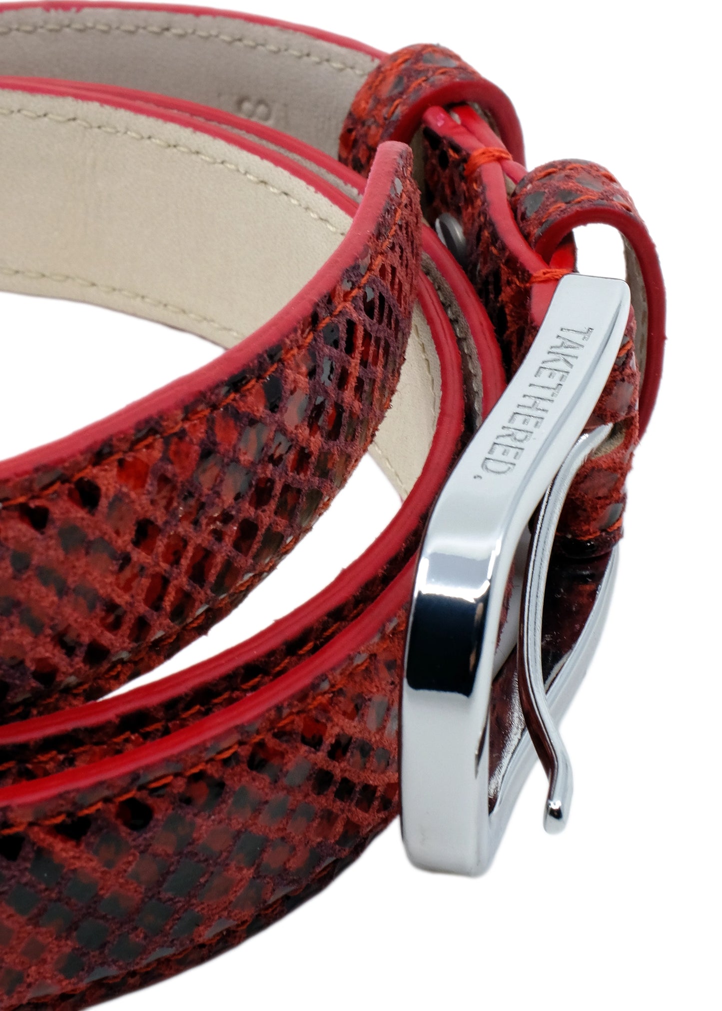 Extreme high-angle macro of the Blood Red snakeskin belt, focusing on the polished silver buckle's top edge and branding.