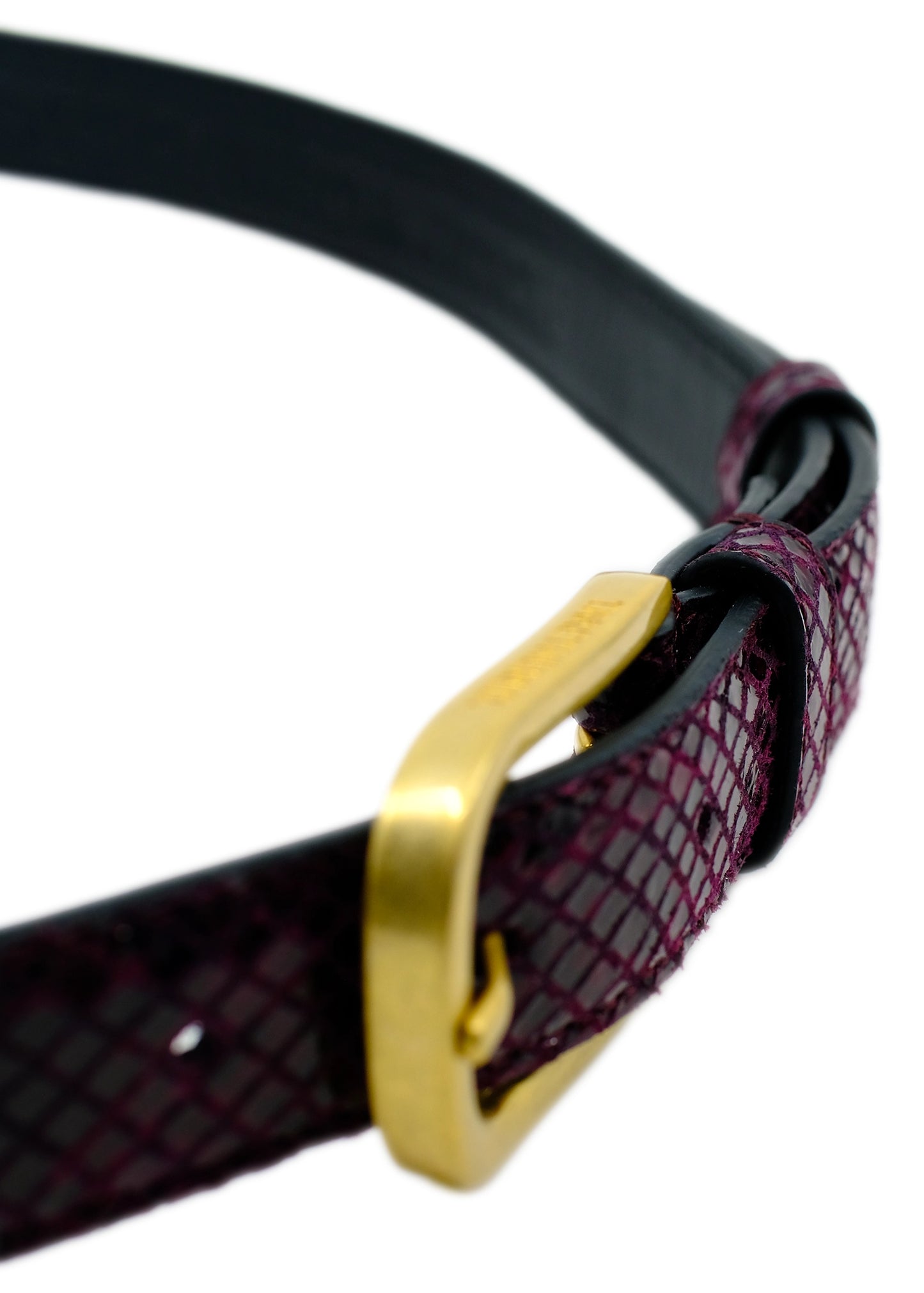 High-angle macro of the Dark Plum snakeskin belt, emphasizing the gold buckle's smooth curve and fine texture.