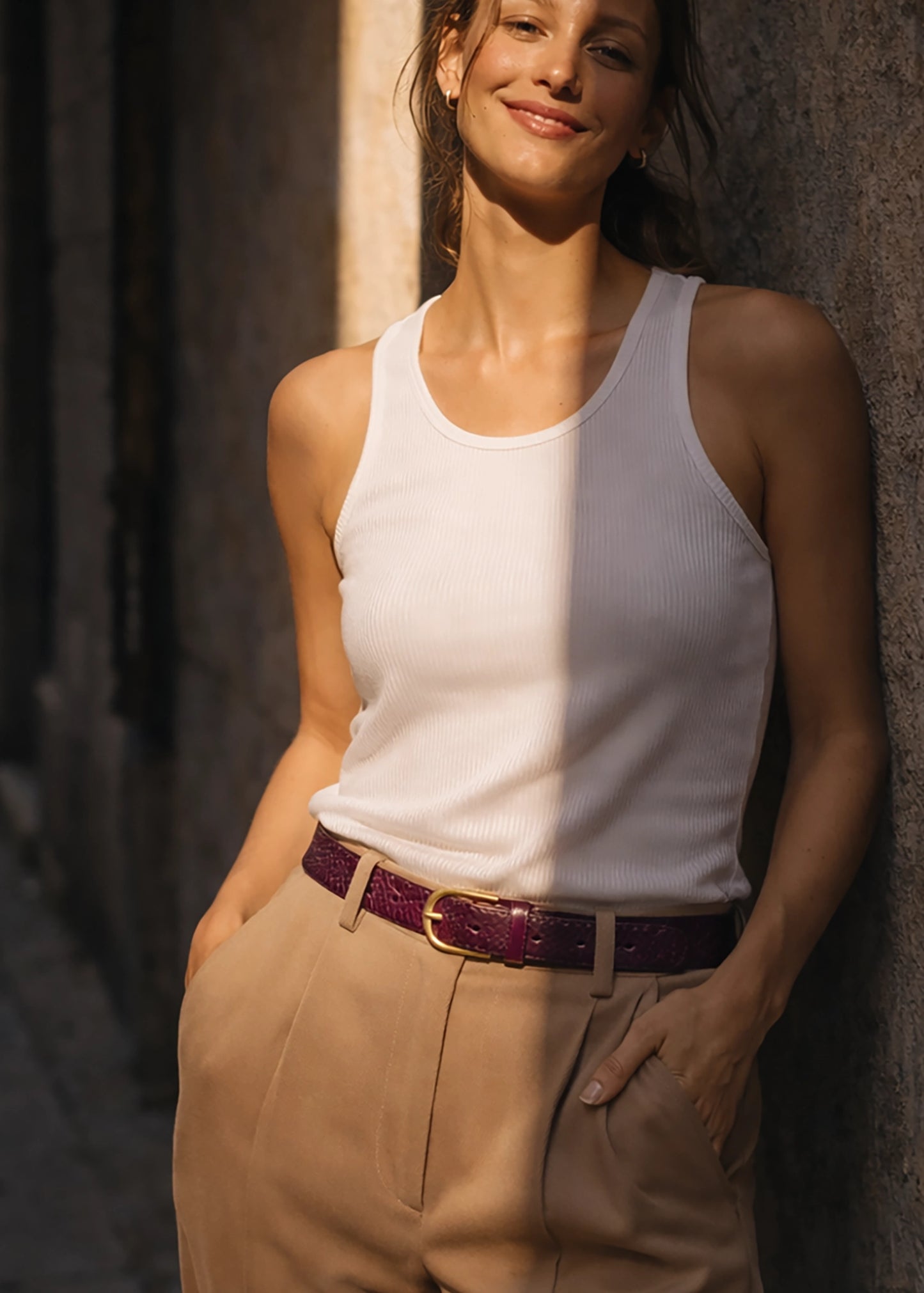 Dark Plum snakeskin belt with gold buckle, styled over beige trousers and a white ribbed tank top.