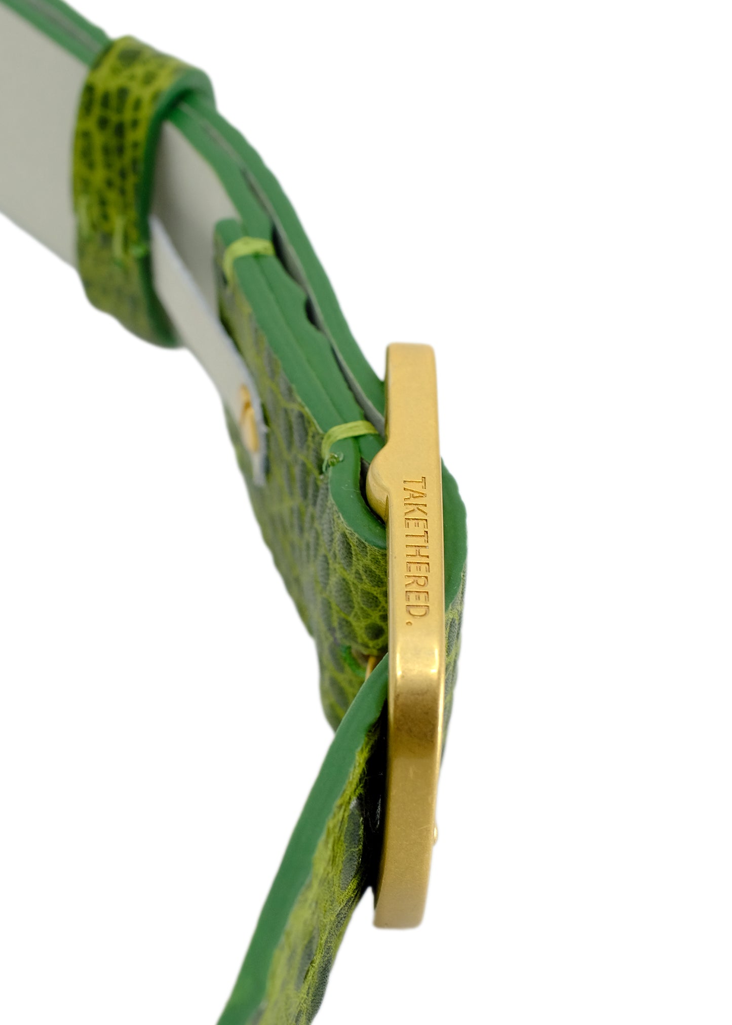 Side-angle macro of the Atomic Green belt, focusing on the gold buckle's engraved branding and the high-contrast alligator leather texture.