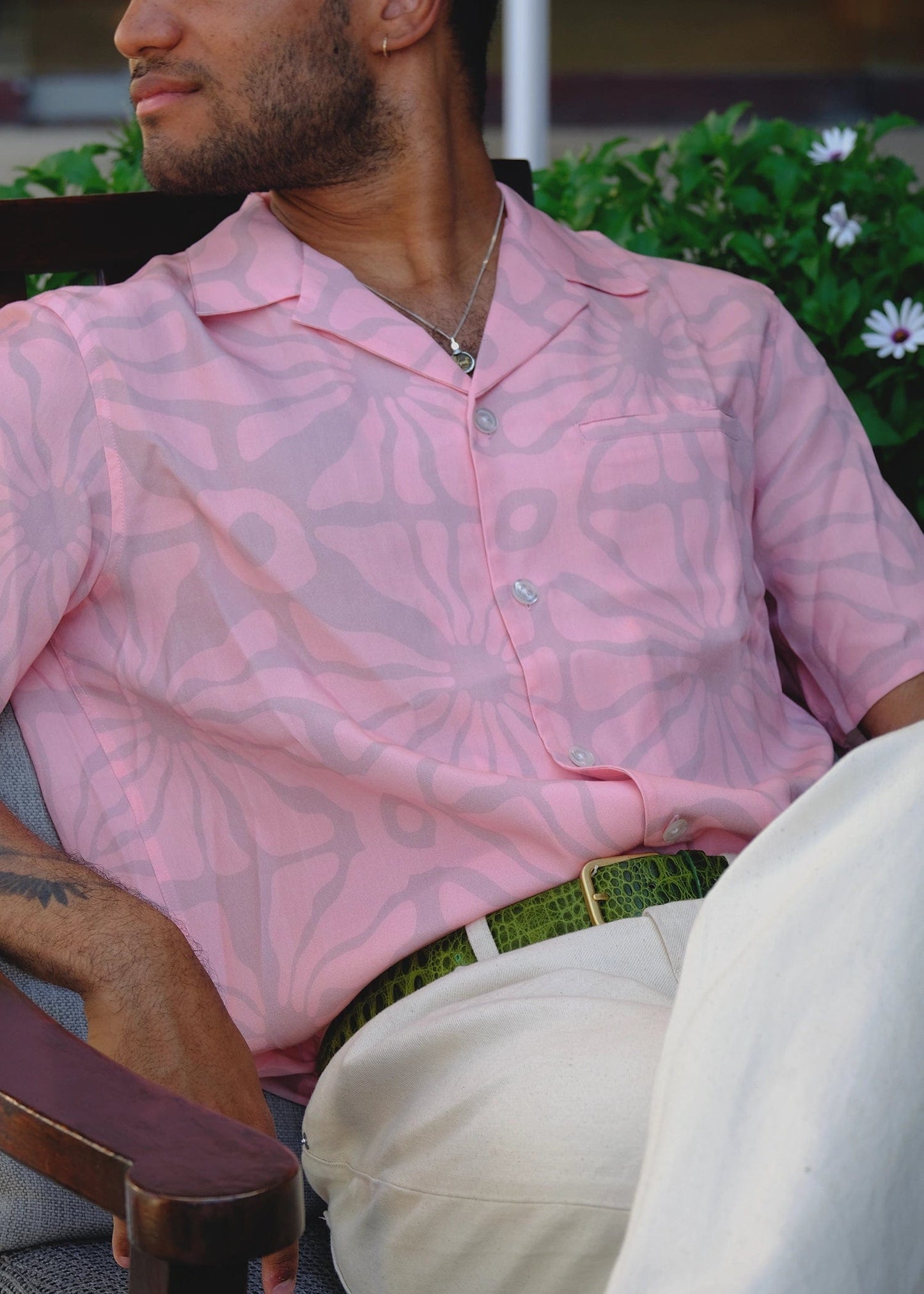 Lifestyle shot of the green alligator-embossed Mississippi Belt worn with beige trousers and a pink shirt.