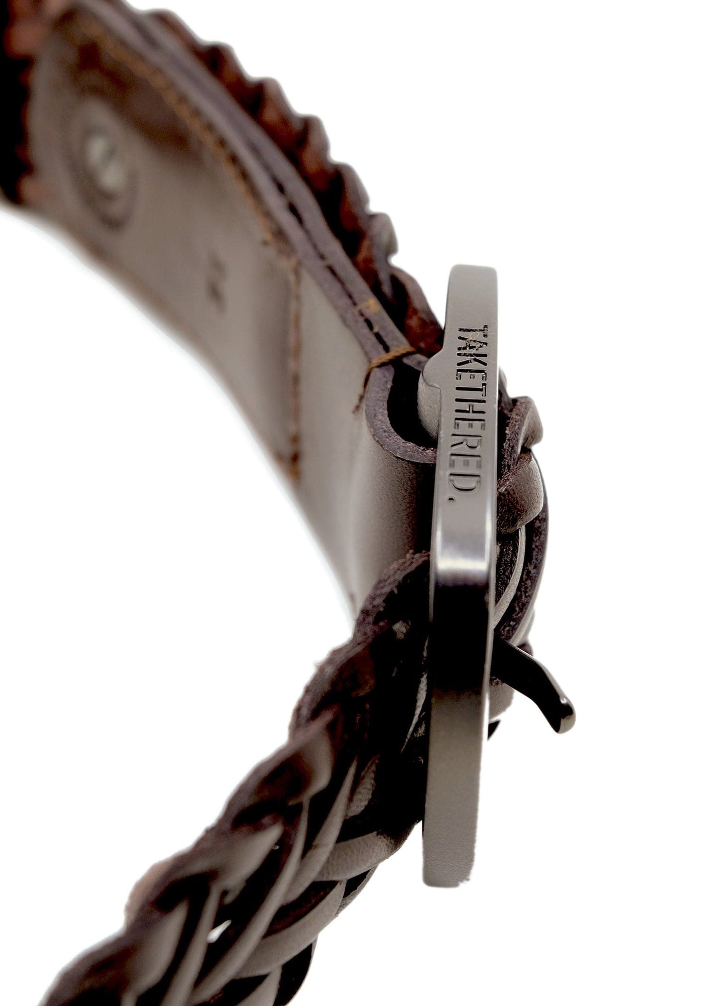 Macro shot of Espresso braided leather belt showing the side of the matte black buckle with "BIRD & ASH." engraving.