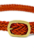 Macro shot of Tatooine Sunset orange braided belt with a matte gold buckle featuring an engraved "TAKETHERED." logo.