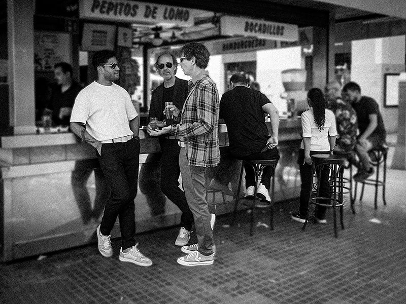 Black and white picture of three men at a bar with classic leather belts and metal buckles